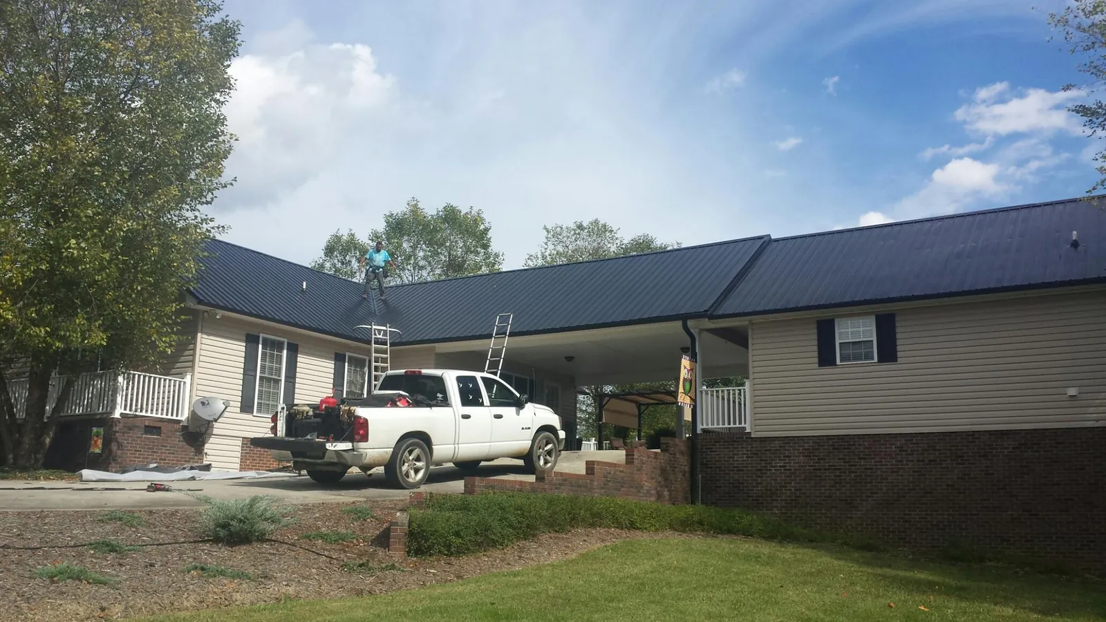 Black metal roof over a home and attached breezeway with ladders set in Augusta